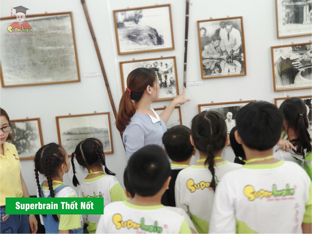 Các bé Superbrain Thốt Nốt  chăm chú nghe cô hướng dẫn kể lịch sử qua từng bức ảnh