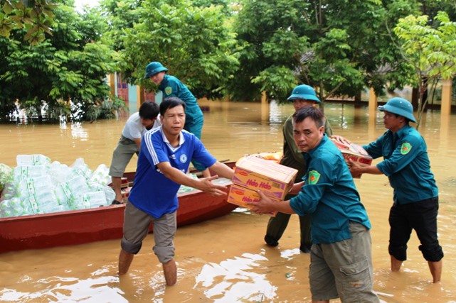 Lực lượng dân quân phối hợp người dân vận chuyển lương thực, nước uống về vùng ngập lũ .